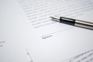Image of a letter with no signature and a pen